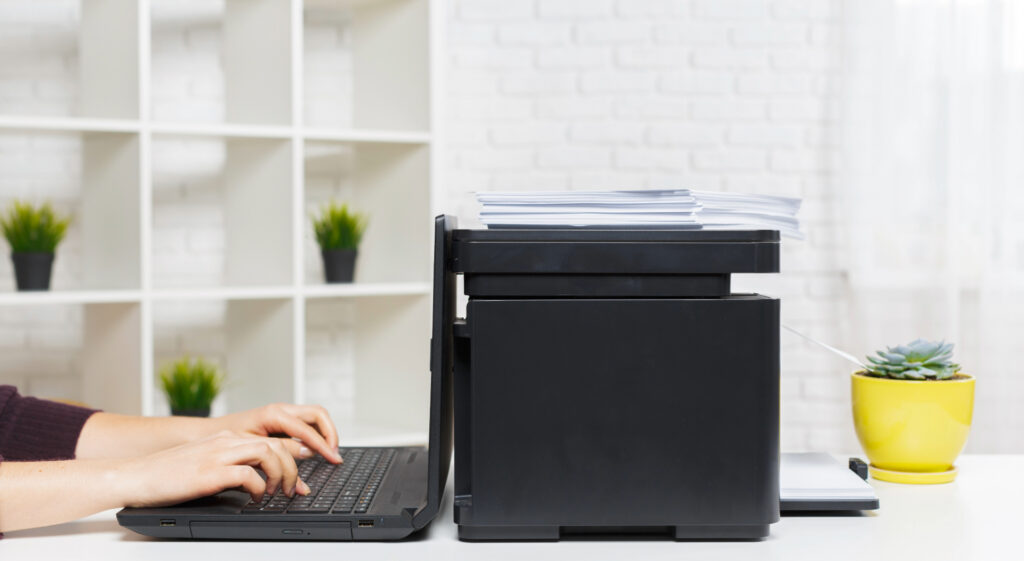 person uses laptop next to printer with documents 2026 03 27 01 44 13 utc 1