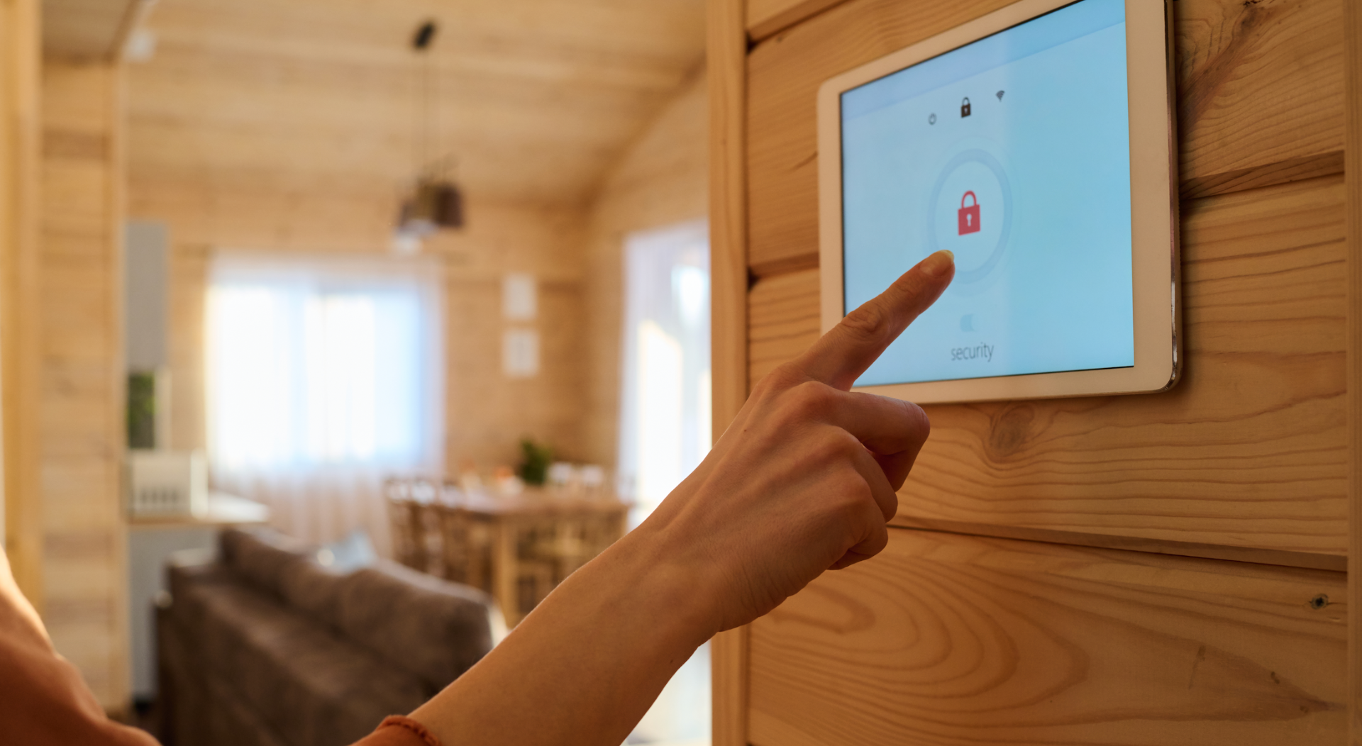 A woman's hand pointing at the security button on a smart home panel