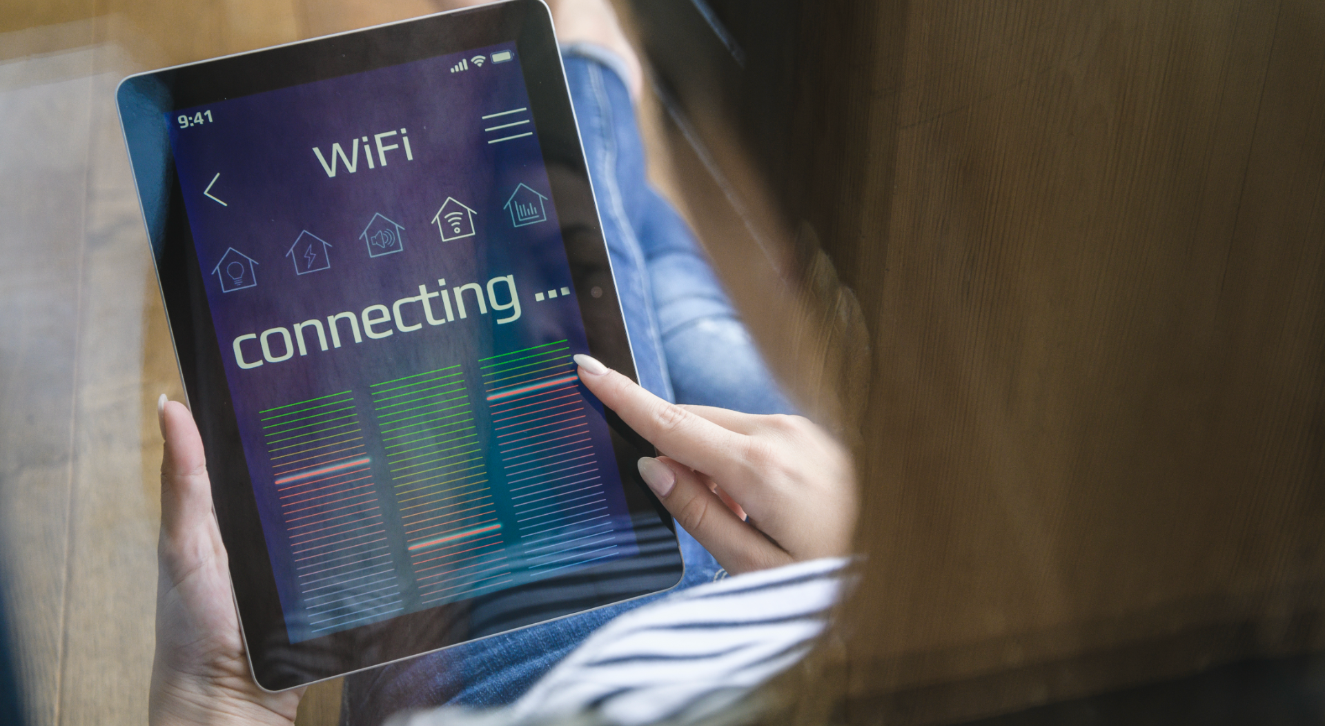 A woman holding a smart home tablet waiting for internet connection